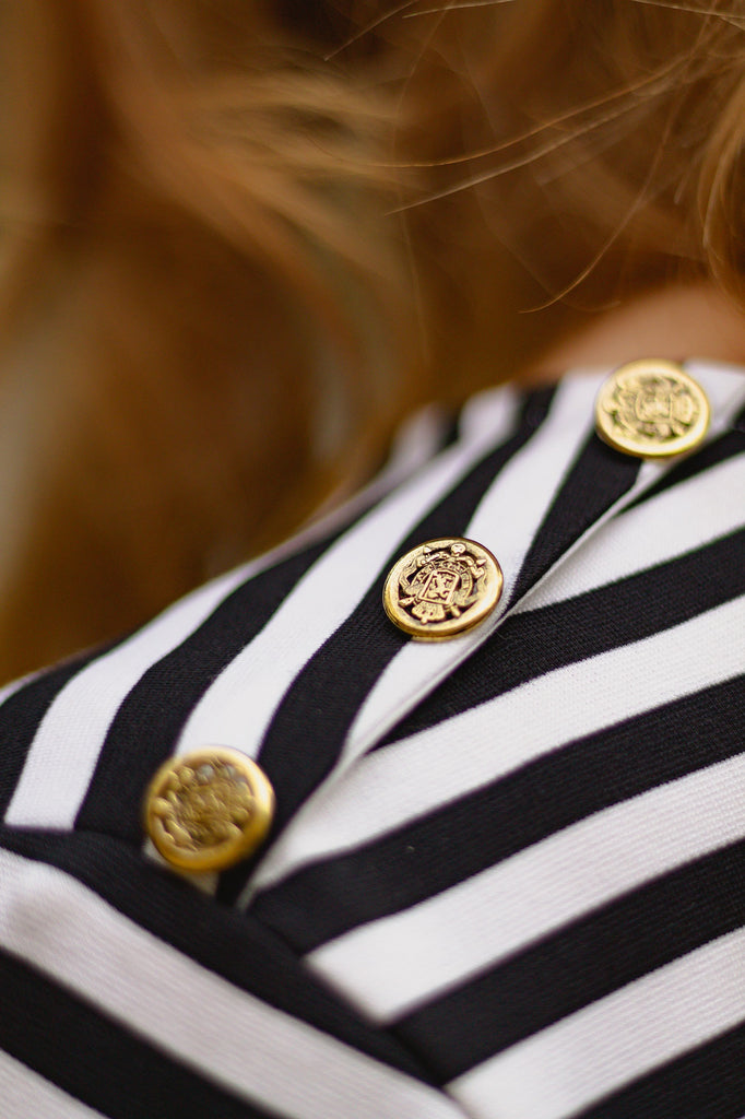 Marinière à rayures blanches et bleu marine, manches longues avec détails de broderies anglaises au poignet et 3 boutons dorés à l'épaule gauche. Prêt à porter fabriqué en France en petites séries